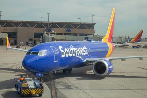 Phoenix, Arizona - A worker driving a tractor pushes a Southwest Airlines jet back from the gate as