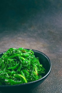 Chuka salad, made from fresh seaweed, with sesame dressing, served in a black bowl