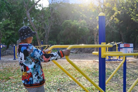 Bangkok, Thailand. March 4th 2025. An elderly lady uses the public outdoor gym exercise machines in