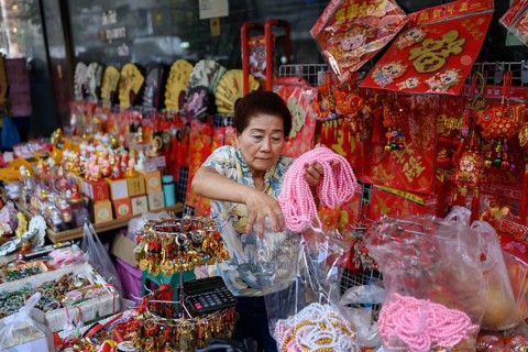 Bangkok, Thailand. February 18th 2025. A woman selling Chinese souvenirs and gifts from a street