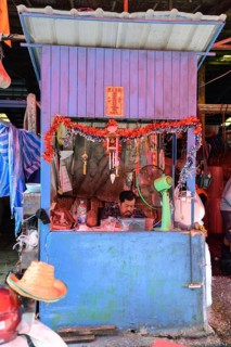 Bangkok, Thailand. February 19th 2025. A worker sits inside a colourful booth at the Khlong Toei