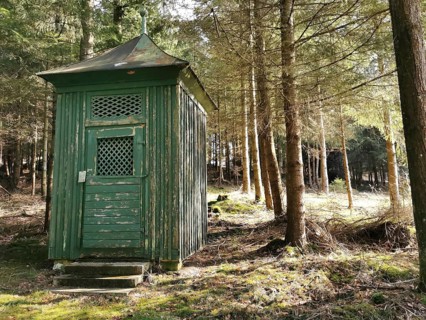 Small green wooden chapel in the forest in sunshine, hiking in the Franconian Forest nature park