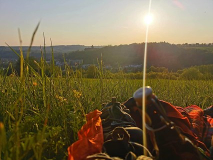 A picnic in a meadow as the sun sets and a panoramic view of the Rosenberg Fortress, Kronach,