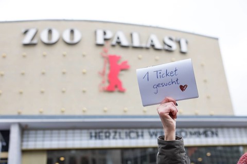 A visitor holds up a note with the inscription 1 ticket wanted for the film Everything Everywhere
