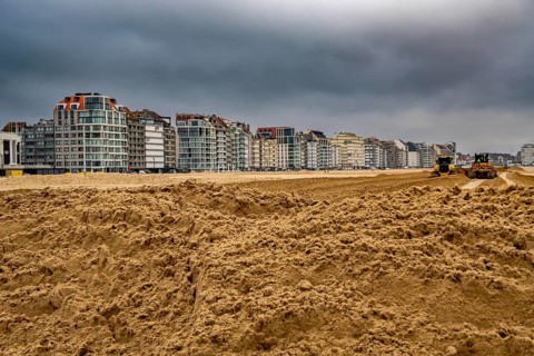 Bulldozers when distributing sand on the beach in the town of Knokke-Heist, part of coastal