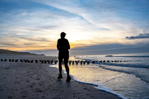 Winter on the North Sea, sunset at the beach, joggers, beach walkers, coastal protection, through