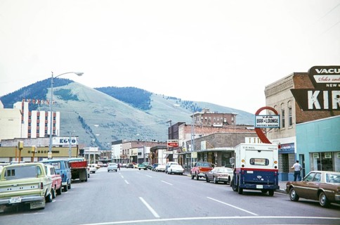 Vehicles on road Main Street in town downtown shopping area of Missoula, Montana, USA 1977 view to