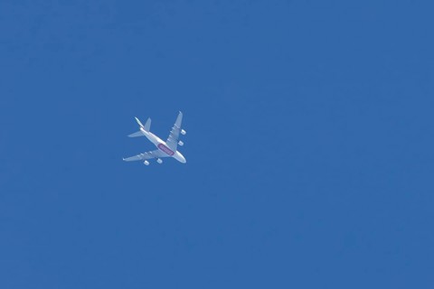 Airbus A380 commercial passenger airliner jet aircraft of Emirates airlines flying in a blue sky,