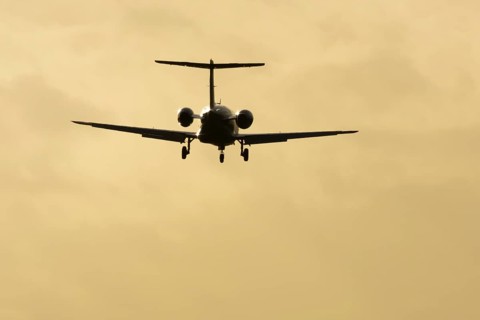 Cessna Citation small executive business jet aircraft in flight on approach to land at sunset at