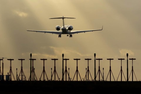 Executive business jet aircraft in flight on approach to land at sunset at London Stansted airport,