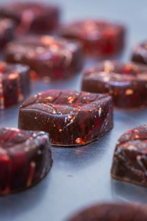Close-up of a reddish shimmering chocolate with a smooth surface, vegan chocolates production,
