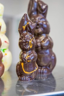 Close-up of a dark-colored chocolate bunny with decoration, Easter production of regional products,
