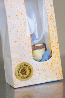 White gift box with colorful splashes and visible logo, Easter production of regional products,