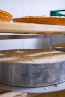 Large cakes prepared on wooden shelves in a bakery, Easter production of regional products,