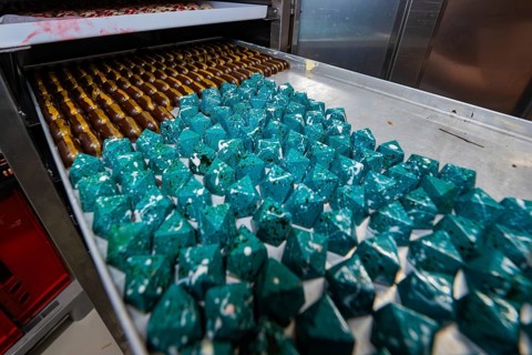 Blue geometric chocolates with shiny surface in rank and file, Easter production of regional