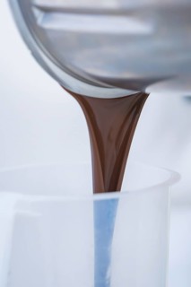 Liquid chocolate is poured into a container, Vegan Tart Production, Haselstaller Hof, Gechingen,