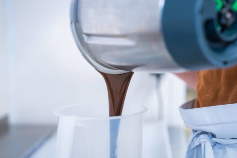 Liquid chocolate is poured from a mixer, Vegan Tarts Production, Haselstaller Hof, Gechingen,