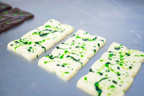 White chocolate bars with green patterns lying side by side on a table, vegan chocolate production,