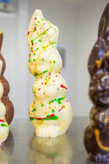 White chocolate figure with colorful food decorations, Easter production of regional products,