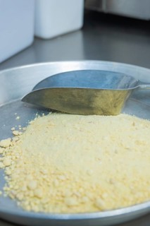 A tray with a metal scoop full of yellow powder in a kitchen, chocolate quail eggs, Easter