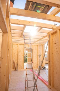 Interior of a wooden building panel with sun rays through ceiling opening, timber house building,