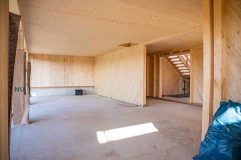 Empty interior of a timber house under construction with visible wooden walls, timber house