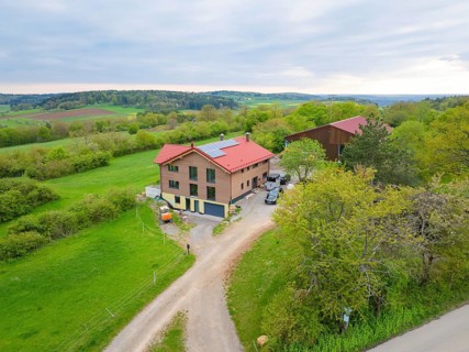 Farmhouse in green landscape under partly cloudy sky, timber house building, Gechingen, Germany