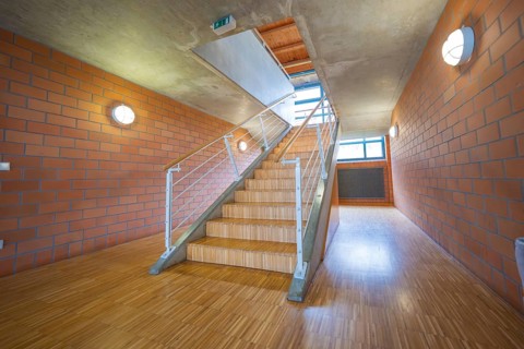 Staircase with wooden floor and brick walls, modern and bright corridor, Schlehengäu sports hall