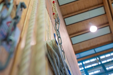 Rope suspension in a sports hall with wooden paneling and lamp light, Schlehengäu Sporthalle
