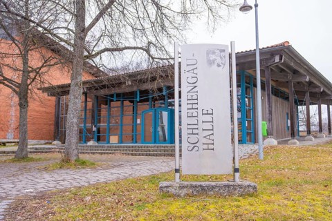 Schlehengäu Halle building with sign in front of it, surrounded by trees, winter atmosphere,