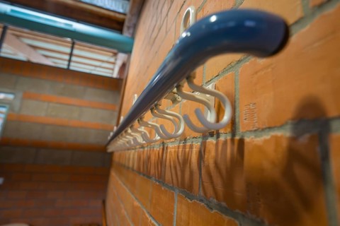 White coat hooks on a brick wall from a close perspective, Schlehengäu Sporthalle Gechingen, Calw