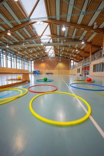 Colourful rings and balls on the floor in a large, well-lit sports hall, Schlehengäu Sporthalle