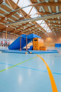 Gymnastic equipment and mats in the wooden sports hall, bright and spacious atmosphere, Schlehengäu