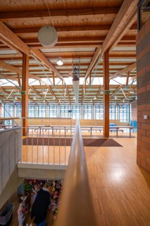 Extensive hall with wooden structure and windows across the entire wall height that let in plenty