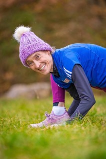 Woman wearing colorful winter clothes smiling in a meadow, relaxed and joyful atmosphere, middle
