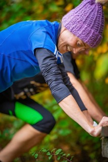 Close-up of a woman doing outdoor training in autumn, wearing sportswear and smiling, middle