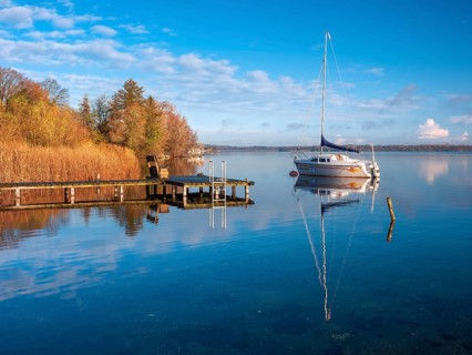 Jetty and sailboat at Schaalsee in morning light, reeds in autumn colors, Schaalsee Biosphere