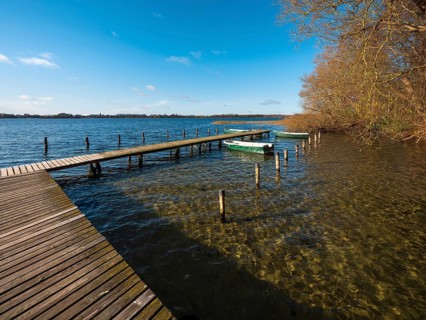 Jetty with rowing boats at Schaalsee in autumn, Schaalsee Biosphere Reserve, Mecklenburg-Western