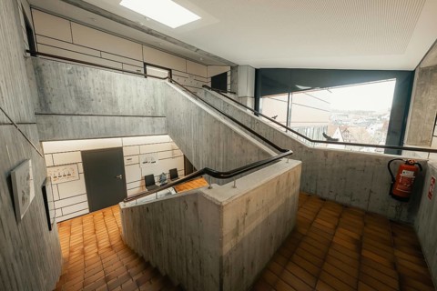 Functional staircase with concrete walls and skylight, minimalist aesthetics, Gechingen Town Hall,