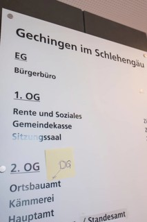 Guide in the building shows various offices and floors, bright room with lettering, Gechingen Town