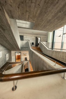 Modern staircase with concrete walls and wooden details, open architecture, interior view,
