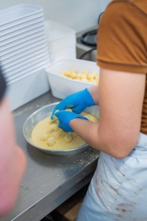 Person breading round foods in a bowl in a kitchen situation, chocolate quail eggs, Easter