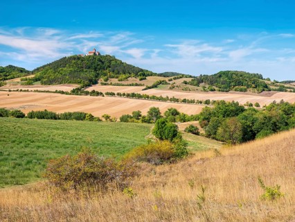 View of hilly landscape with meadows, fields and forests of Wachsenburg Castle in summer,