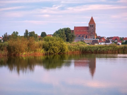 Tribsee with St. Thomas Church in the evening, reflection in a lake, North German brick Gothic,