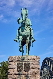 Equestrian statue of Emperor Frederick III, bridge, arched steel arches, sandstone pedestal, tree,