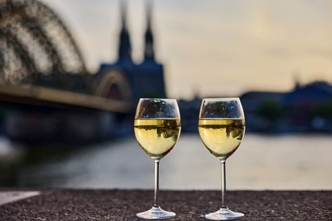 Wine glasses, wine, light refraction in filled glasses, concrete wall, Rhine river, Hohenzollern