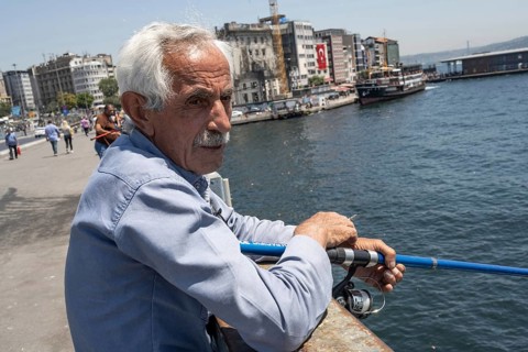 Istanbul, Turkey. June 23rd 2025. An old Turkish man fishing on the Galata Bridge near Karikoy