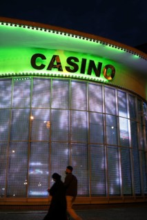 Tbilisi, Georgia. September 4th 2025. A tourist couple walk past an illuminated window for a casino