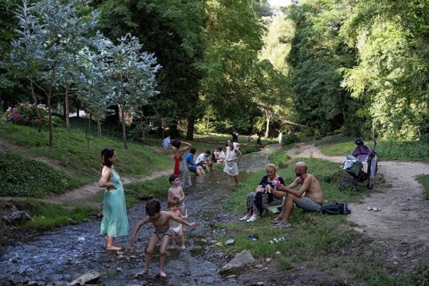 Tbilisi, Georgia. July 13th 2025. Georgian families enjoy the shade and cold water stream of the