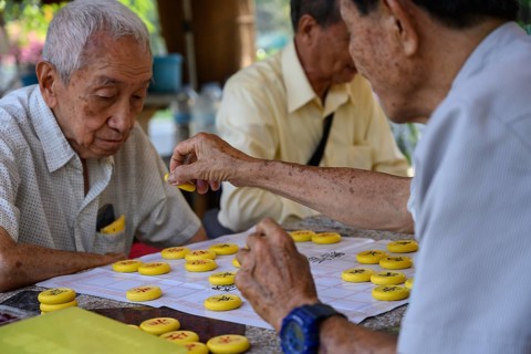 Bangkok, Thailand. March 4th 2025. Old men play Chinese board games on a Sunday morning in Lumphini